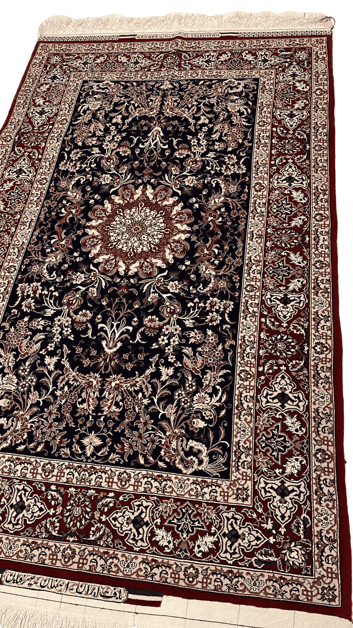 "Close-up of intricate floral and medallion patterns on a Master Bagher Seirafian Persian rug, made with silk and wool."